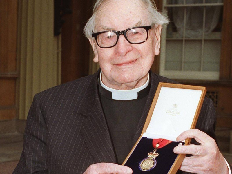 Ein Pastor wird mit einer Medaille ausgezeichnet.