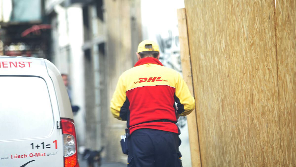 Ein Paketbote der DHL stellt eine Sendung zu.