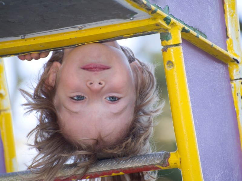 Ein Kind spielt auf einem Klettergerüst auf einem Spielplatz.