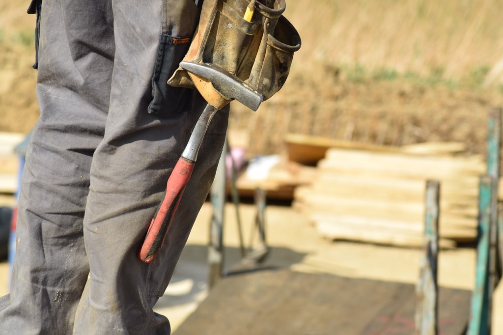 Ein Bauarbeiter mit Hammer am Gürtel.