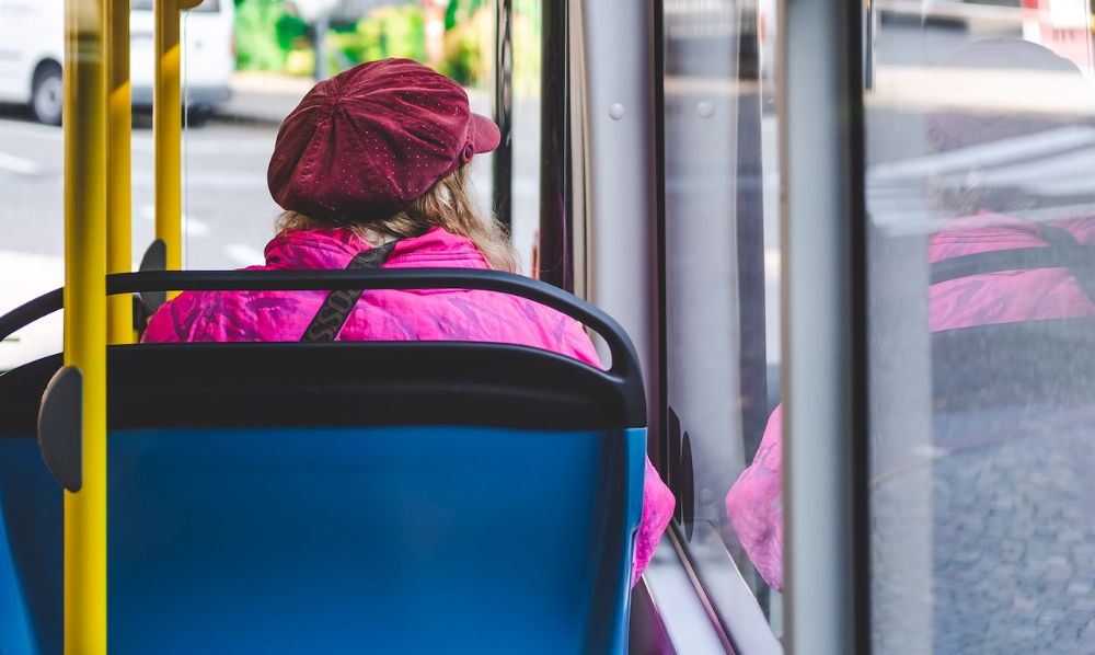 Eine alte Frau sitzt im Bus.