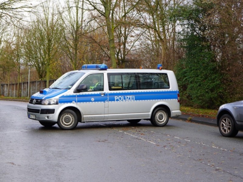 Ein Polizeiwagen versperrt eine Straße für eine Straßenkontrolle.