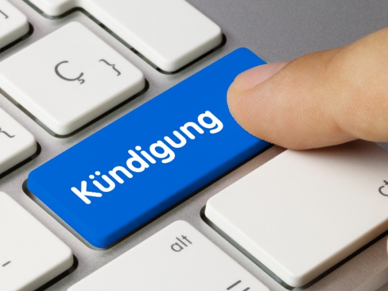 Finger drückt auf eine Taste mit der Aufschrift "Kündigung".